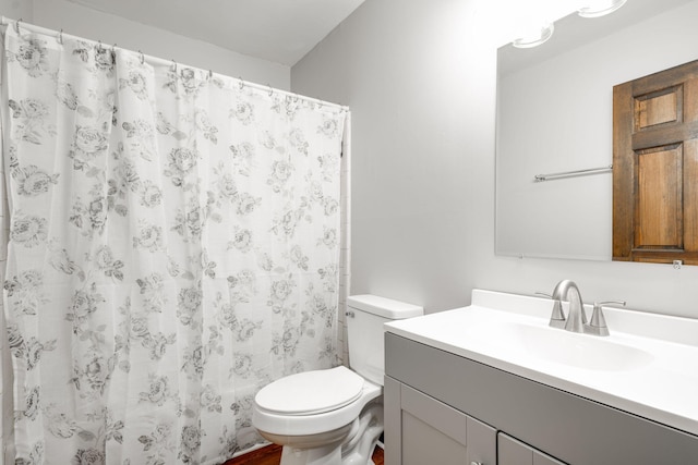 bathroom featuring curtained shower, vanity, and toilet