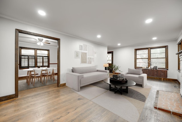 living room featuring light hardwood / wood-style floors, ceiling fan, and ornamental molding