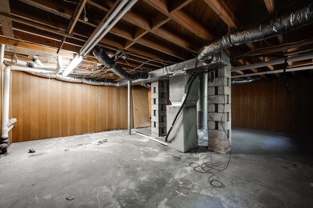 basement featuring wooden walls