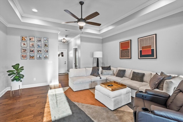 living room featuring crown molding, hardwood / wood-style flooring, a tray ceiling, and ceiling fan