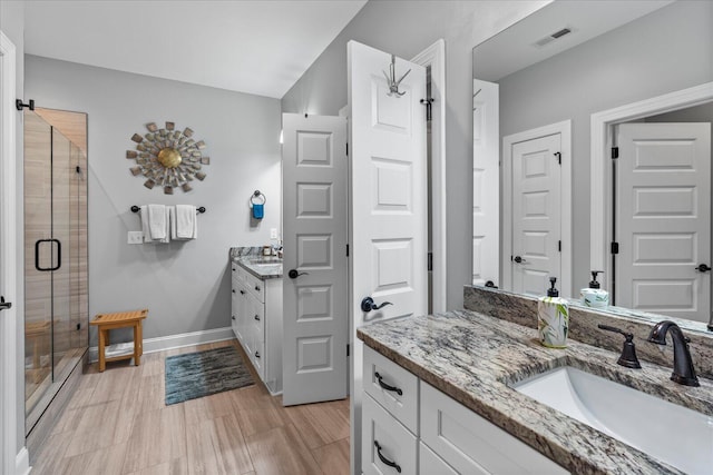 bathroom with vanity and a shower with door