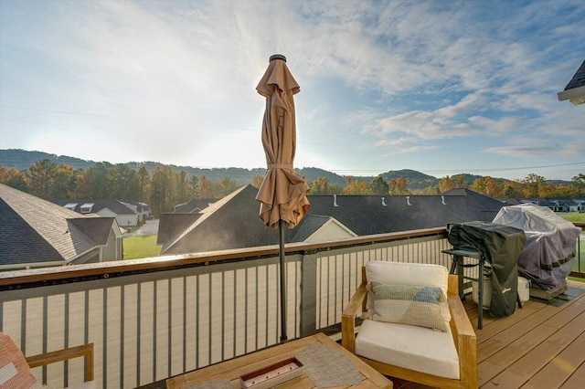 wooden terrace featuring a mountain view and a grill