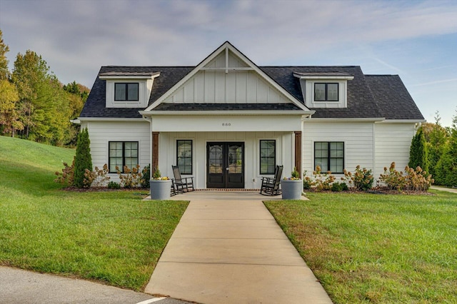 view of front facade with french doors, a front lawn, and covered porch