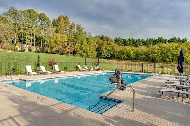 view of swimming pool with a yard and a patio