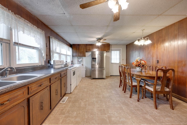 kitchen with wood walls, stainless steel fridge, and plenty of natural light