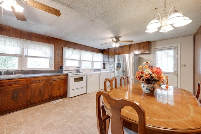 kitchen with white range with electric stovetop, stainless steel refrigerator with ice dispenser, sink, and a wealth of natural light