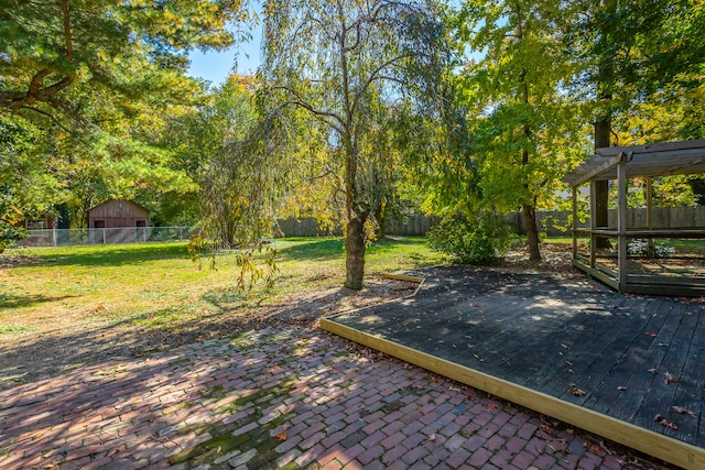 view of patio with a wooden deck and a storage unit