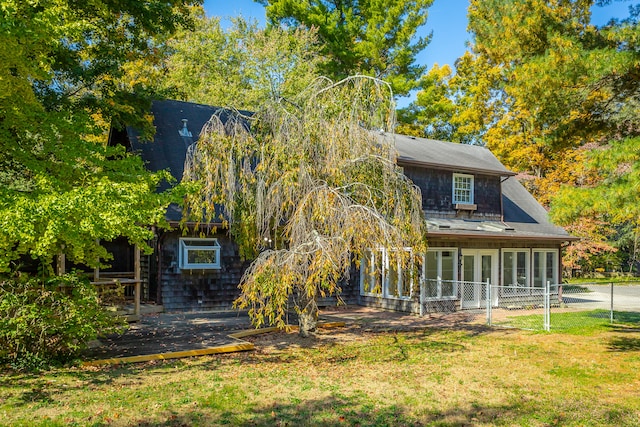 back of house featuring a sunroom and a lawn