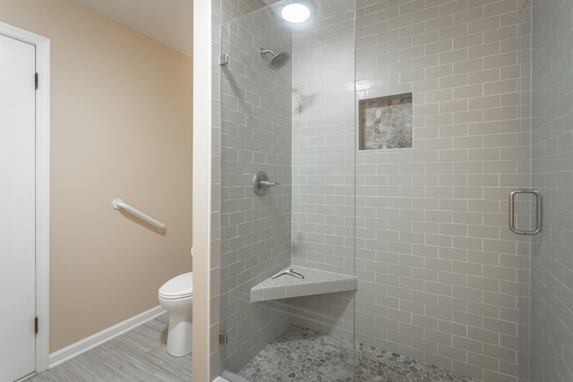 bathroom featuring a shower with shower door and toilet