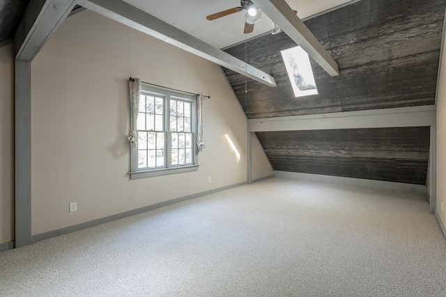 additional living space featuring carpet, ceiling fan, and vaulted ceiling with skylight