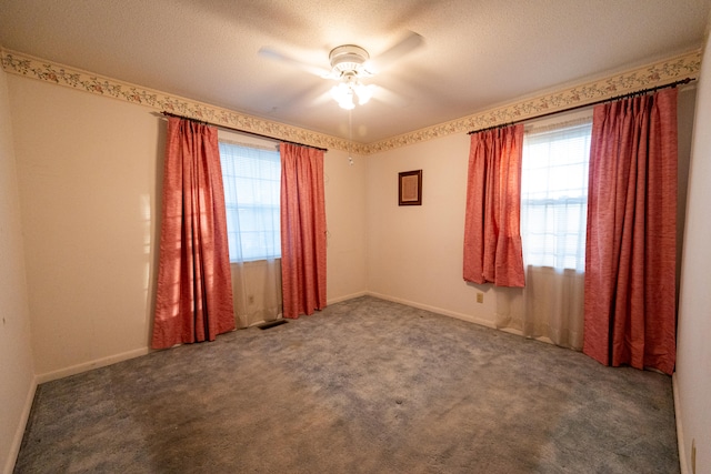 carpeted empty room featuring ceiling fan and a textured ceiling