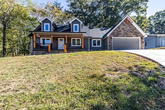 view of front facade featuring a porch, a front lawn, and a garage