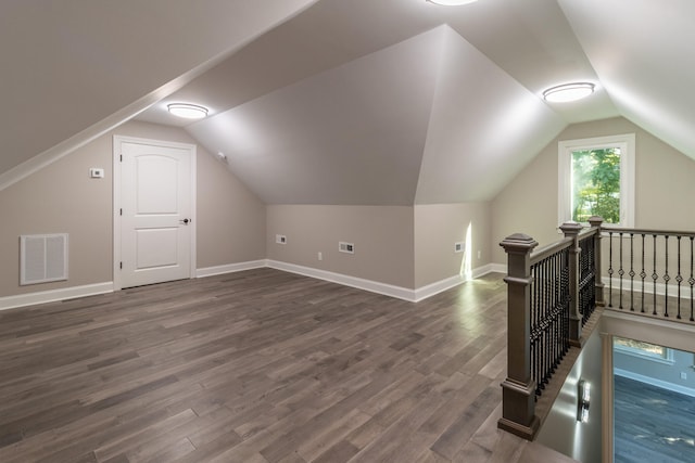 bonus room with vaulted ceiling and dark hardwood / wood-style floors