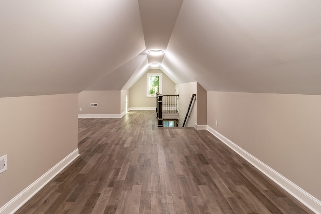 bonus room with vaulted ceiling and dark hardwood / wood-style flooring