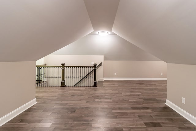 additional living space with dark wood-type flooring and vaulted ceiling