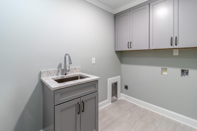 laundry room with electric dryer hookup, washer hookup, sink, crown molding, and cabinets