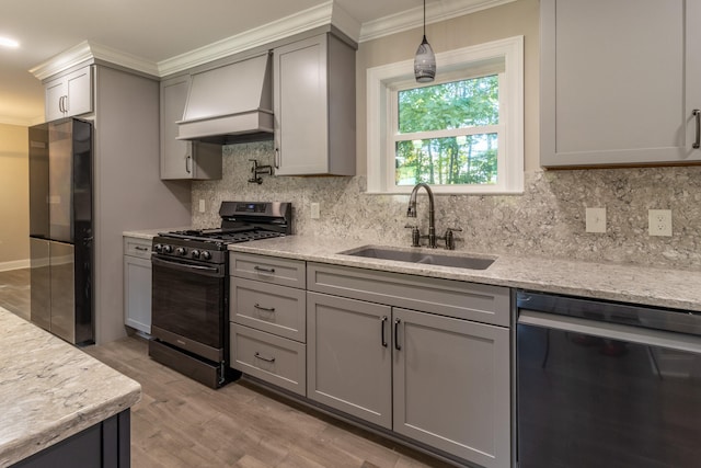 kitchen with appliances with stainless steel finishes, premium range hood, sink, and gray cabinets