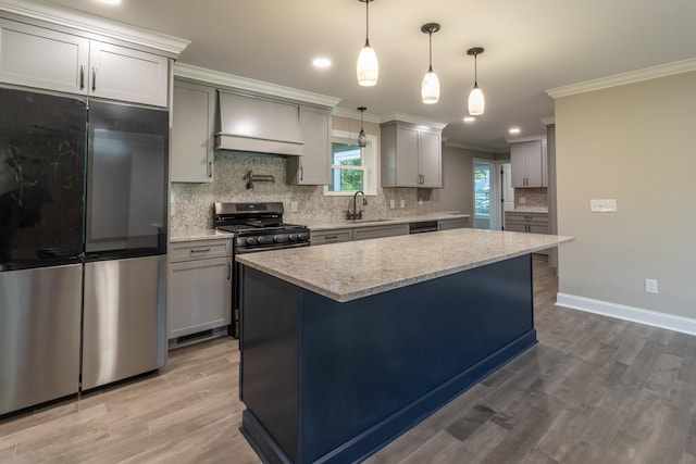 kitchen featuring gray cabinetry, light stone countertops, wood-type flooring, stainless steel appliances, and pendant lighting