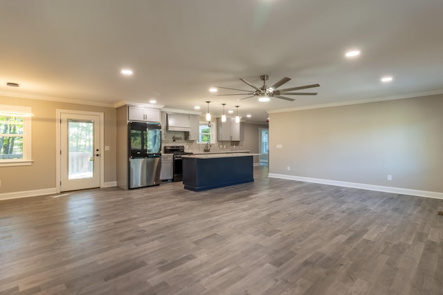 kitchen featuring white cabinetry, hardwood / wood-style flooring, stainless steel appliances, and hanging light fixtures