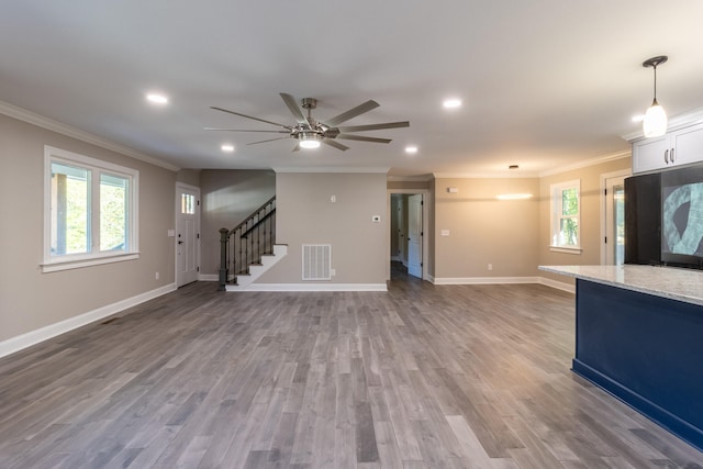 unfurnished living room featuring crown molding, wood-type flooring, and ceiling fan