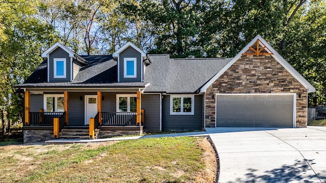 view of front of house with covered porch, a garage, and a front lawn