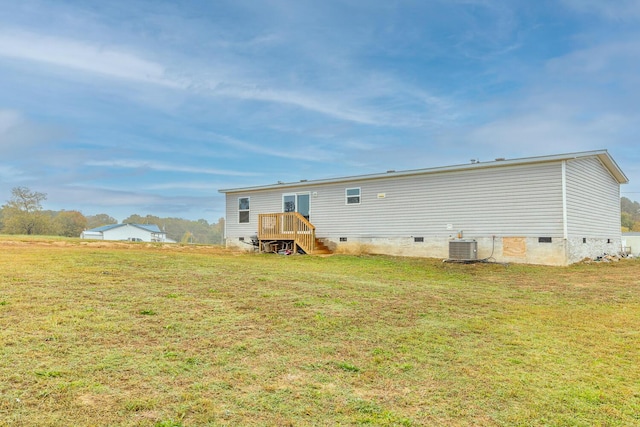 rear view of property with a yard and central air condition unit