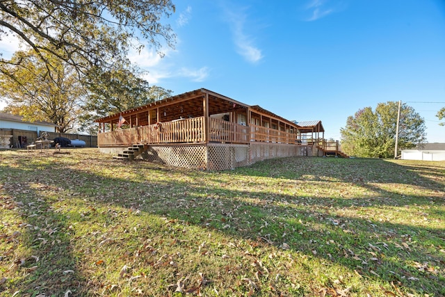 back of property with a deck and a yard