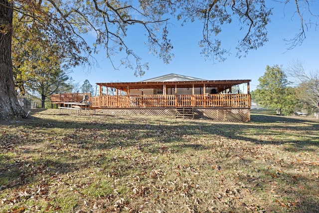 rear view of house with a deck and a yard