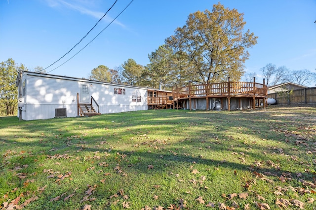 back of house featuring a lawn and a wooden deck