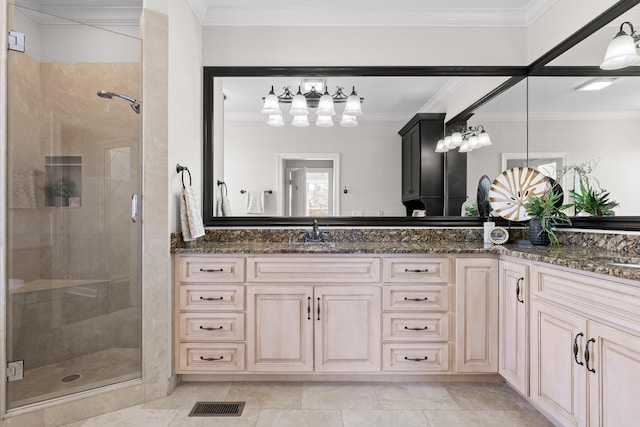 bathroom with tile patterned flooring, vanity, a shower with door, and crown molding