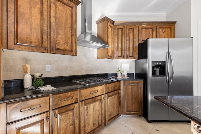 kitchen featuring light tile patterned flooring, dark stone counters, wall chimney range hood, and appliances with stainless steel finishes