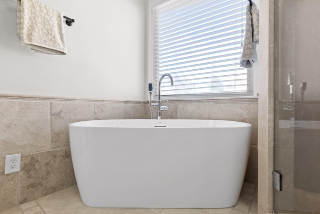 bathroom with tile walls and a tub