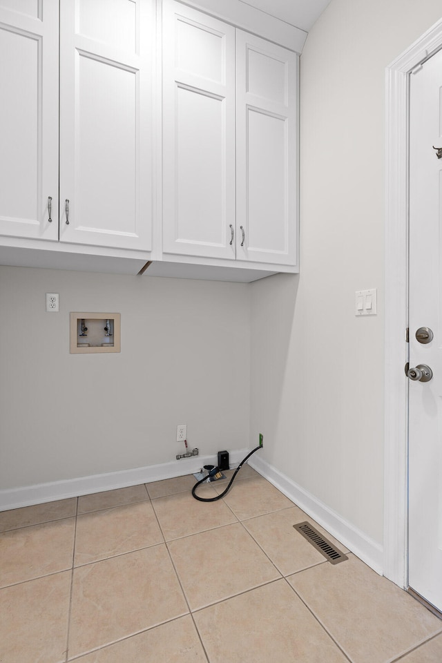 laundry area featuring hookup for a gas dryer, cabinets, light tile patterned floors, and hookup for a washing machine