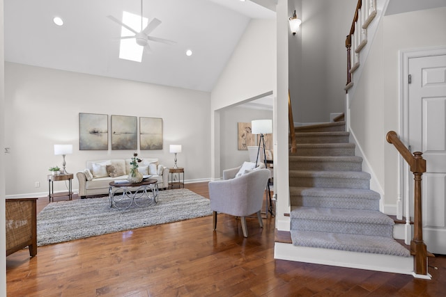 living room with a skylight, ceiling fan, high vaulted ceiling, and hardwood / wood-style flooring