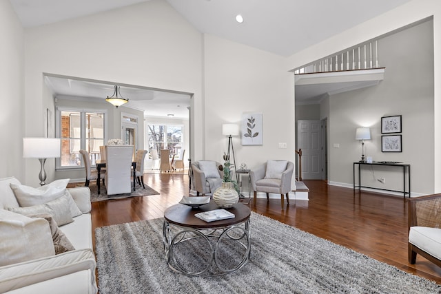 living room featuring dark hardwood / wood-style floors, high vaulted ceiling, and crown molding