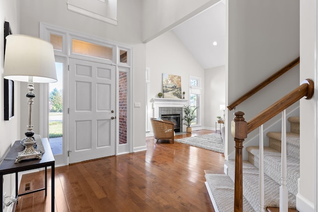 entrance foyer with hardwood / wood-style flooring, plenty of natural light, and high vaulted ceiling