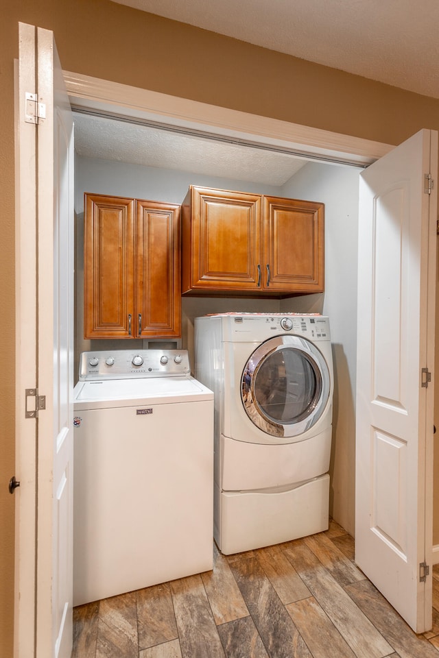 laundry room featuring light wood-type flooring, cabinets, and independent washer and dryer