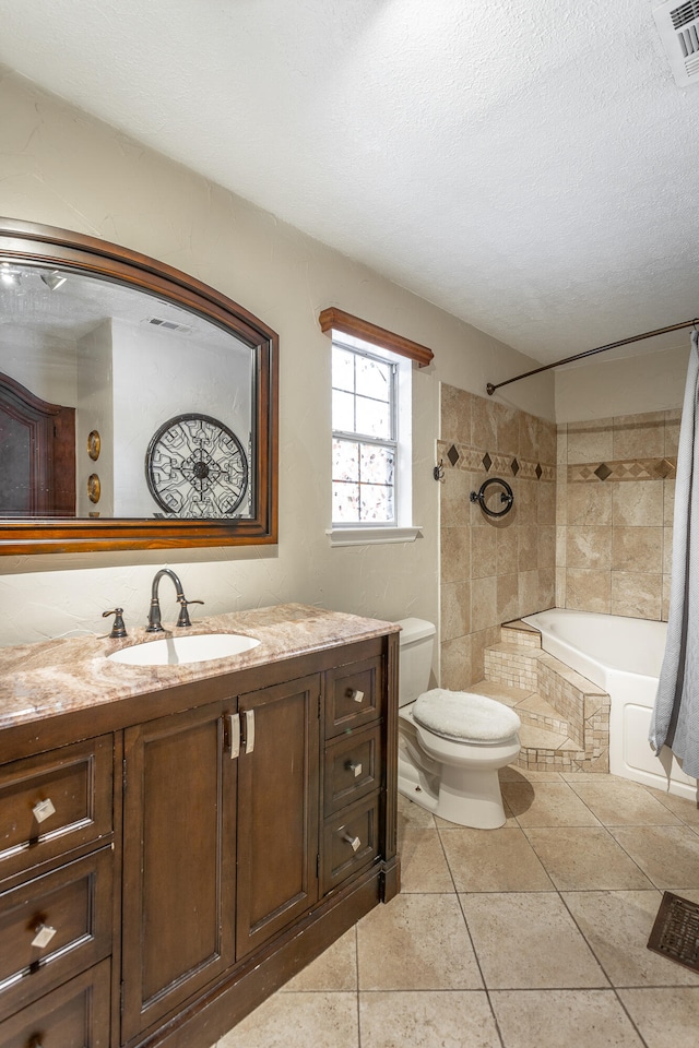 full bathroom featuring tile patterned floors, vanity, a textured ceiling, toilet, and shower / bath combo with shower curtain