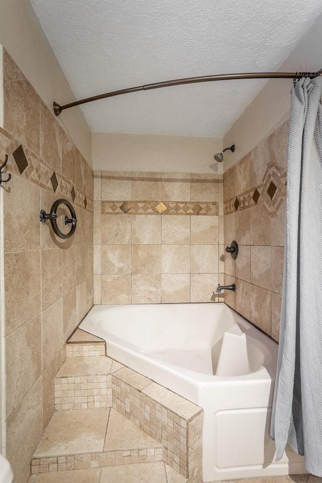 bathroom with a textured ceiling and tile patterned flooring