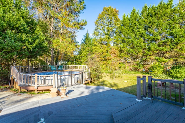 wooden deck featuring a fenced in pool and a lawn