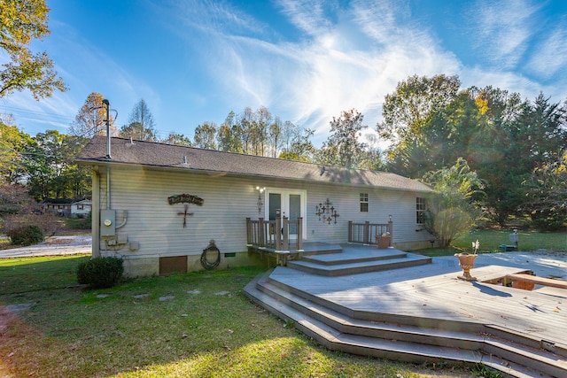 back of house with french doors, a lawn, and a deck