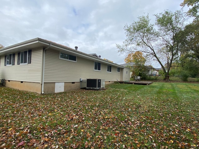 view of side of home featuring central AC unit and a lawn