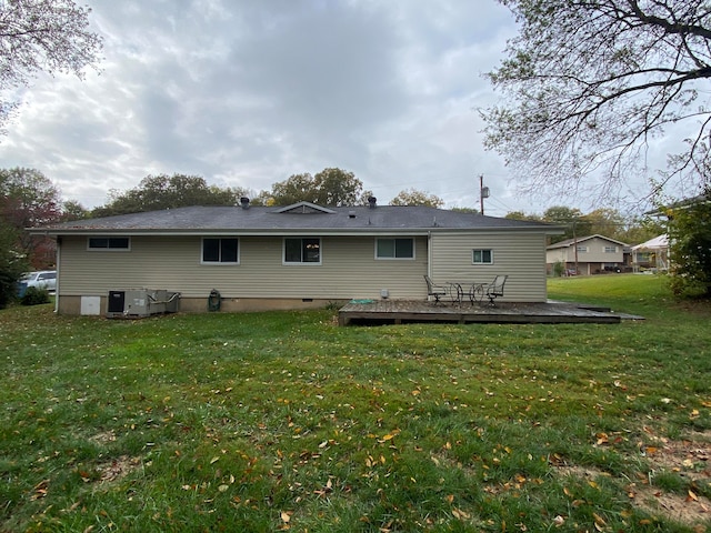 back of property with a lawn and a deck