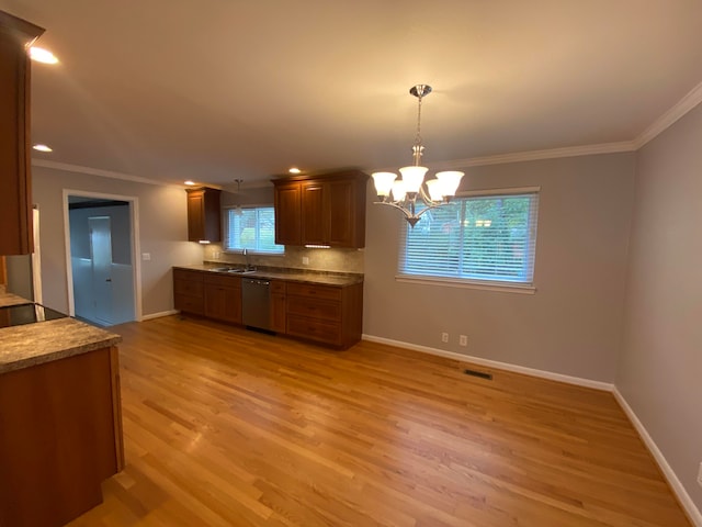 kitchen with light hardwood / wood-style flooring, stainless steel dishwasher, decorative light fixtures, and plenty of natural light