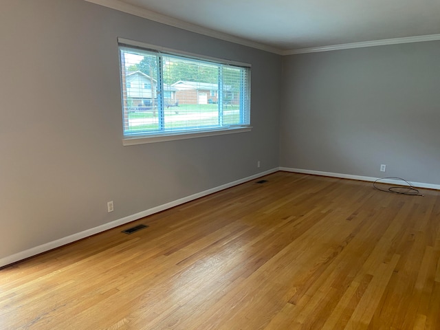 spare room with crown molding and light hardwood / wood-style flooring