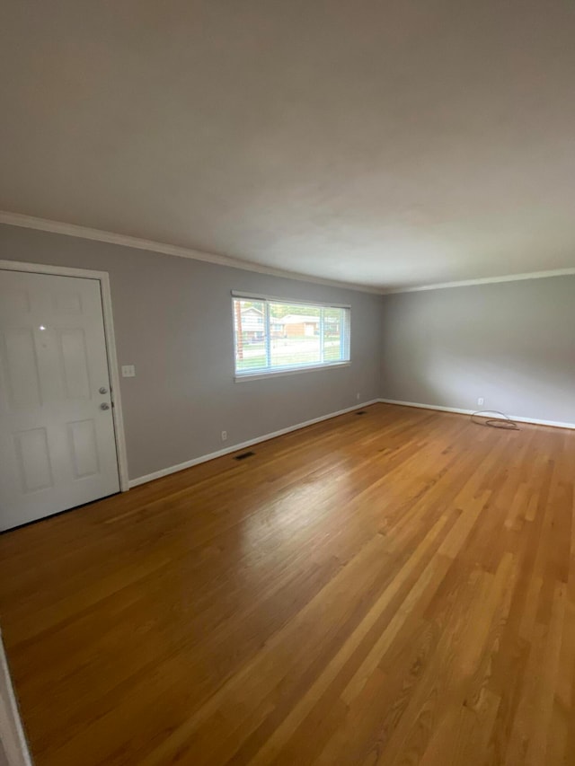 empty room featuring ornamental molding and light hardwood / wood-style floors