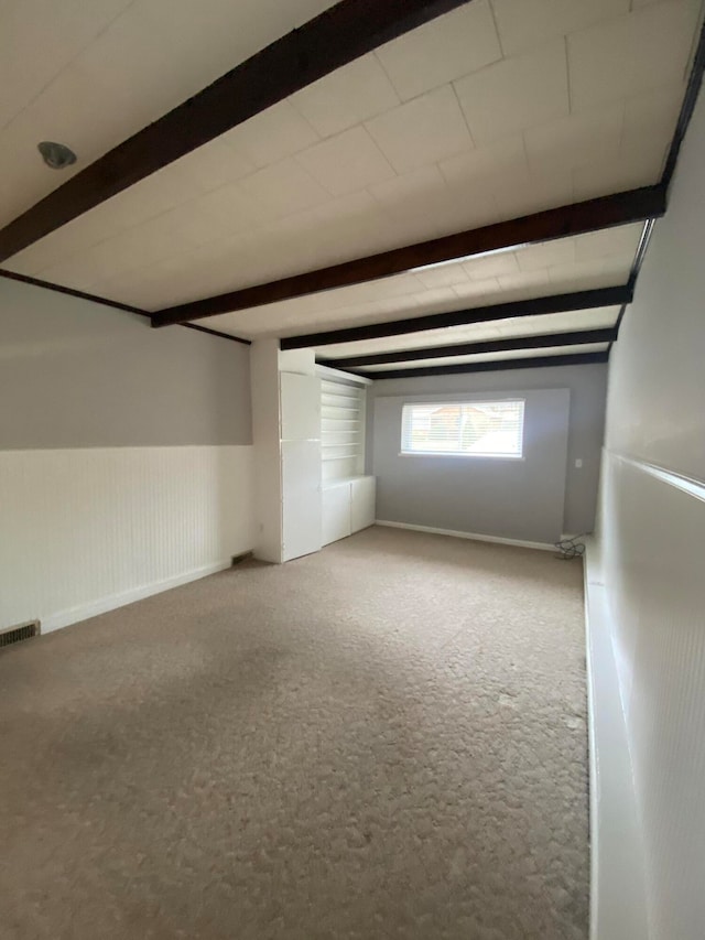 interior space with carpet and beamed ceiling