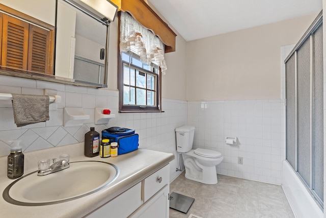 full bathroom featuring toilet, tile walls, tile patterned flooring, bath / shower combo with glass door, and vanity