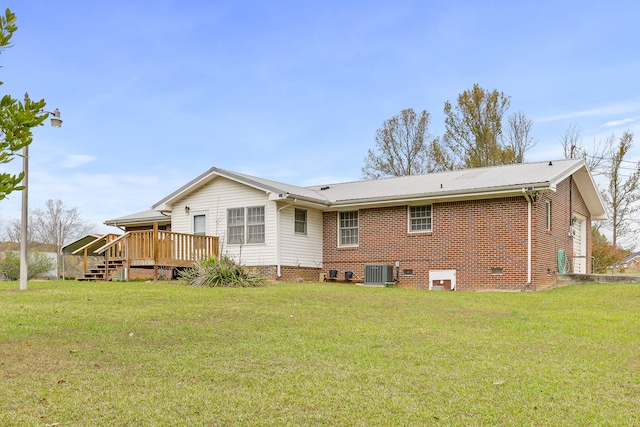 back of house with central AC unit, a wooden deck, and a yard