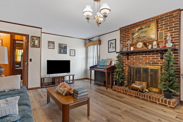 living room featuring an inviting chandelier, hardwood / wood-style floors, ornamental molding, and a brick fireplace